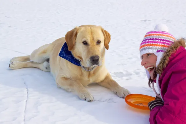 Девушка, прокладки с собакой в снегу — стоковое фото