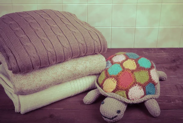 Вязаная игрушка черепаха с стек вязаной одежды на деревянных t — стоковое фото