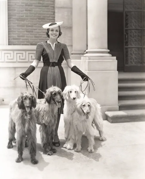 Женщина с собаками, стоя вне — стоковое фото