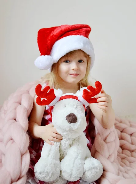 Красивая девочка в новогодней шапке с игрушка собака — стоковое фото