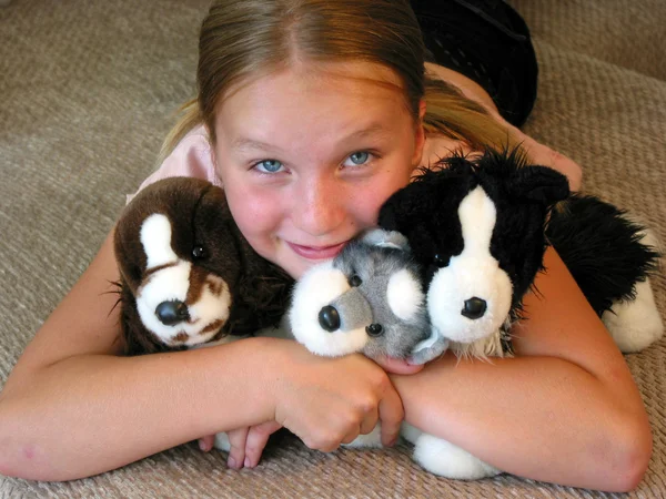 Девочка обнимает ее плюшевые игрушки — стоковое фото